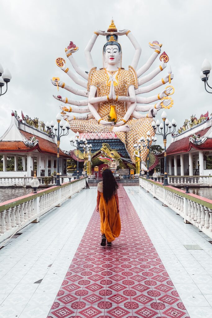 Ragazza con vestito giallo davanti a un tempio in Thailandia come nomade digitale