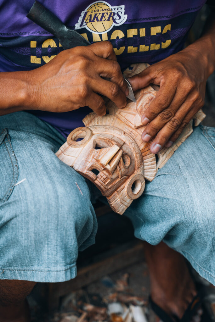 Artigiano a Chichen Itza realizza maschera Maya in legno